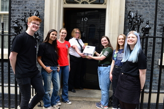 Group of young people handing in a petition at no.10