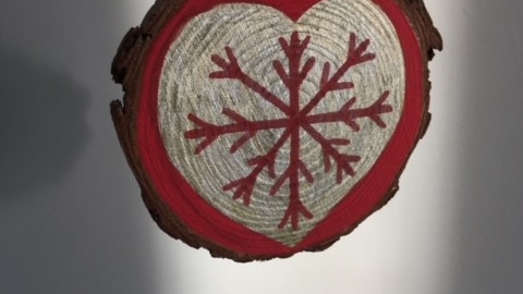 Wooden slice decorated with a gold heart and red snowflake 