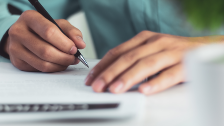 A person writing a letter 