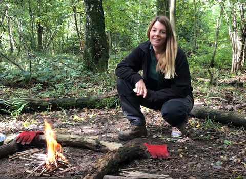 Engagement officer Faye Irvine next to a small campfire