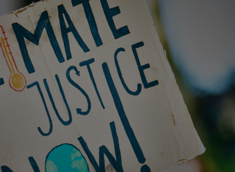 A protest sign saying 'climate justice now'